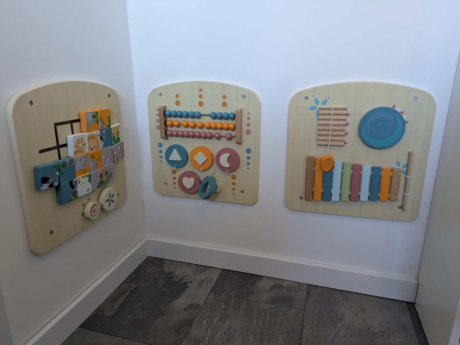 Drie houten speelpanelen aan de muur